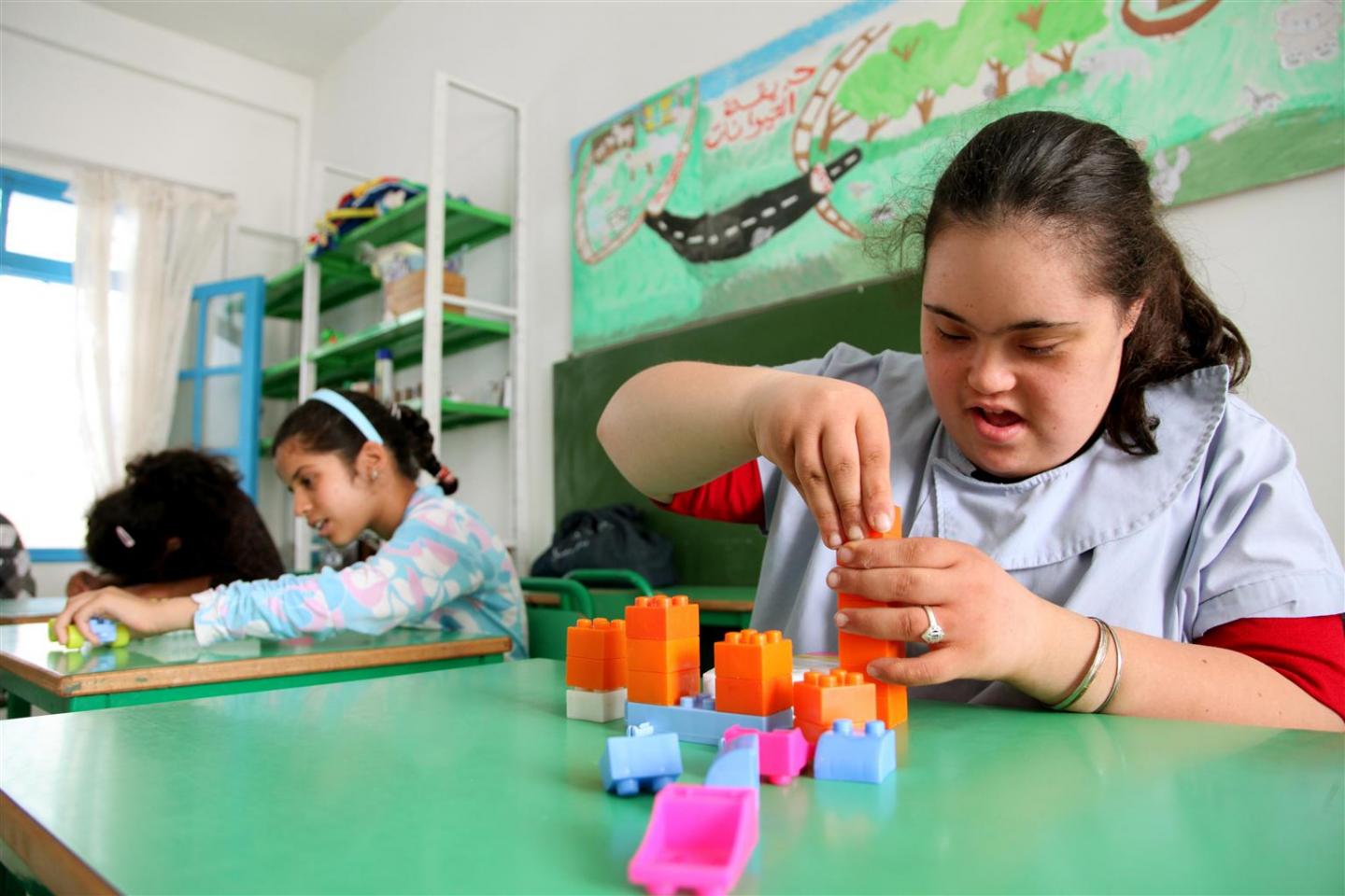A girl who has Down’s syndrome plays with building blocks